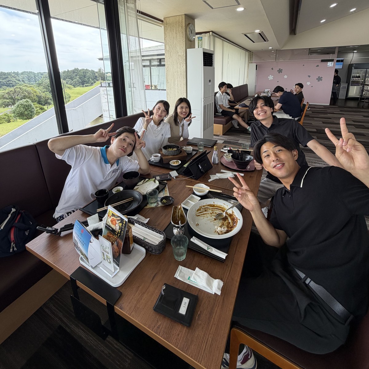 Kyomeiカップ後の食事会でピースサインをするメンバーたち