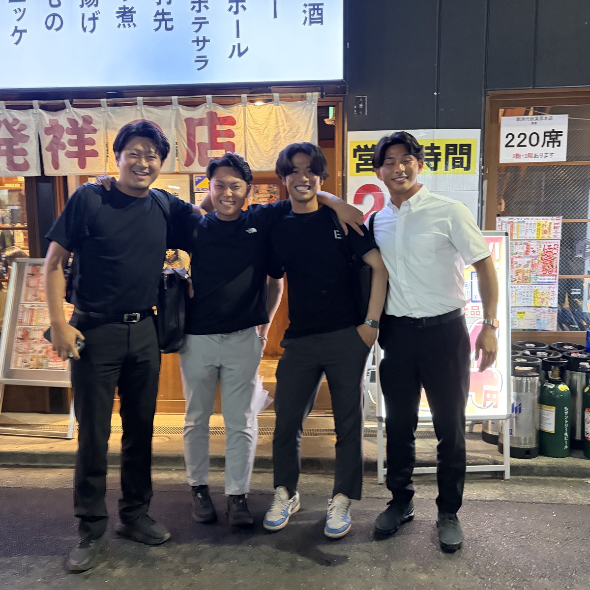 新メンバー歓迎懇親会で串カツ店の前で笑顔を見せるメンバーたち
